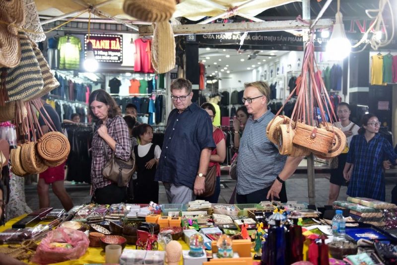 Les touristes occidentaux se promènent sur le marché vietnamien