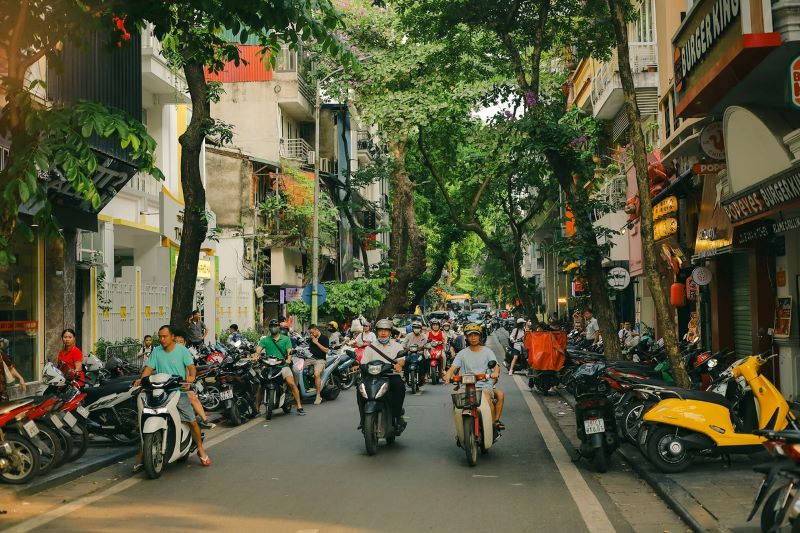 Circulation animée dans les rues du Vietnam avec des scooters et des voitures en mouvement